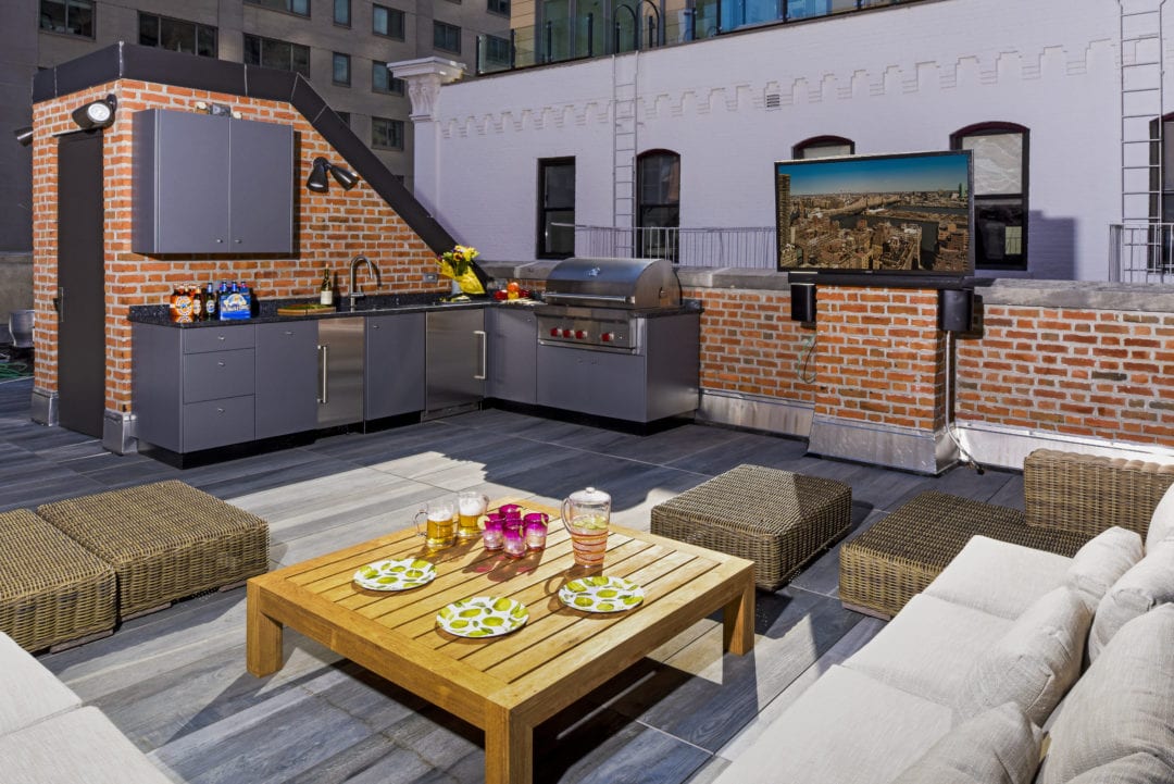 L-shaped kitchens are perfect for maximizing rooftop space such as this design by Atlantic Outdoor with Danver. 