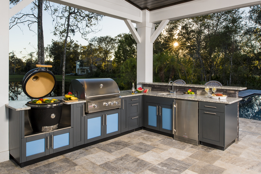 L-shaped outdoor kitchen with bright cabinets